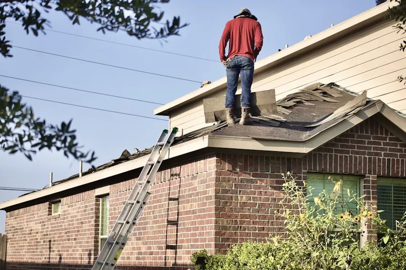 Professional roofer working on a residential roof in Adkins